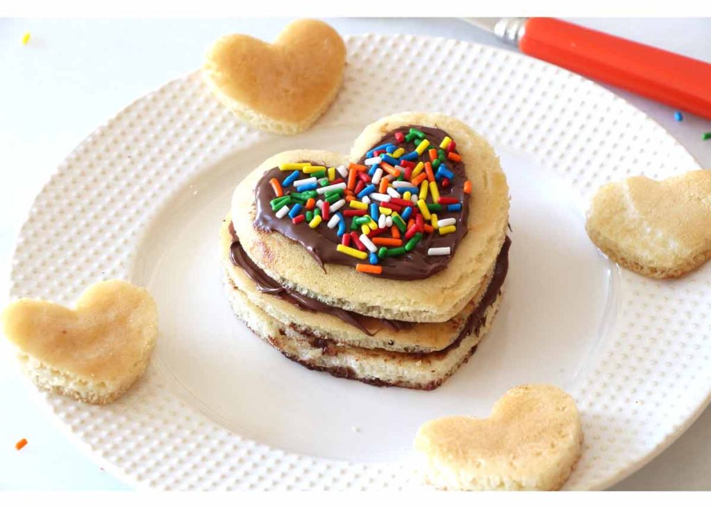 I Heart You Pancake Recipe - that is so easy you use store bought pancakes. This is awesome date food. This is fluffy, filled with Nutella , and lots of smiles every bite. www.ChopHappy.com