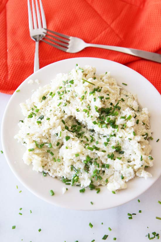 Sour Cream & Chive Cauliflower Mash Recipe is a perfect comfort food side everyone will love. It is quick, easy, and perfect holiday side. Just grab cauliflower, sour cream, chives, butter and lots of seasoning for the perfect recipe. www.ChopHappy.com