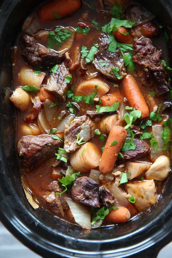 Slow Cooker Beef Bourguignon Recipe. Beef Bourguignon is just a fancy name for buttery beef stew soaked in sweet tangy wine. The original recipe takes more time then this New Yorker has. So I developed a slow cooker version that cooks while I am at work. Just because life is busy doesn't mean you cant have a fabulous dinner to celebrate you! #slowcooker #beefstew