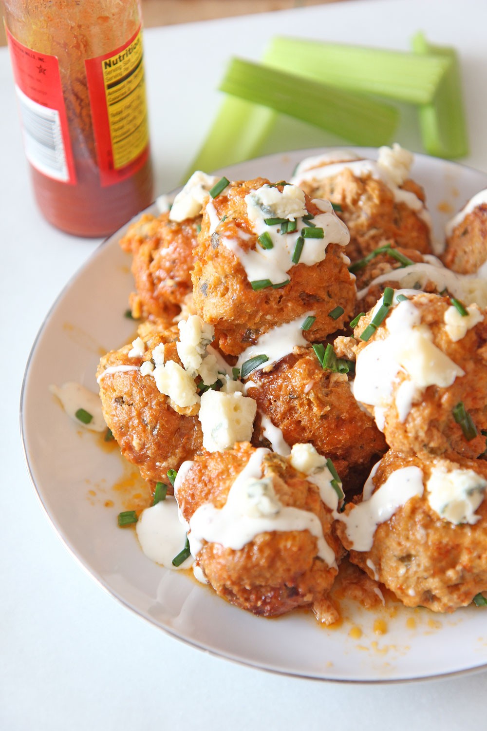 Slow Cooker Buffalo Chicken Meatballs Recipe. Grab chicken, ricotta, celery, eggs, bread crumbs, blue cheese, parsley, and ranch dressing. This is an easy dinner idea for when it is a busy weeknight! Happy cooking! #slowcookerrecipe #chickenmeatballs