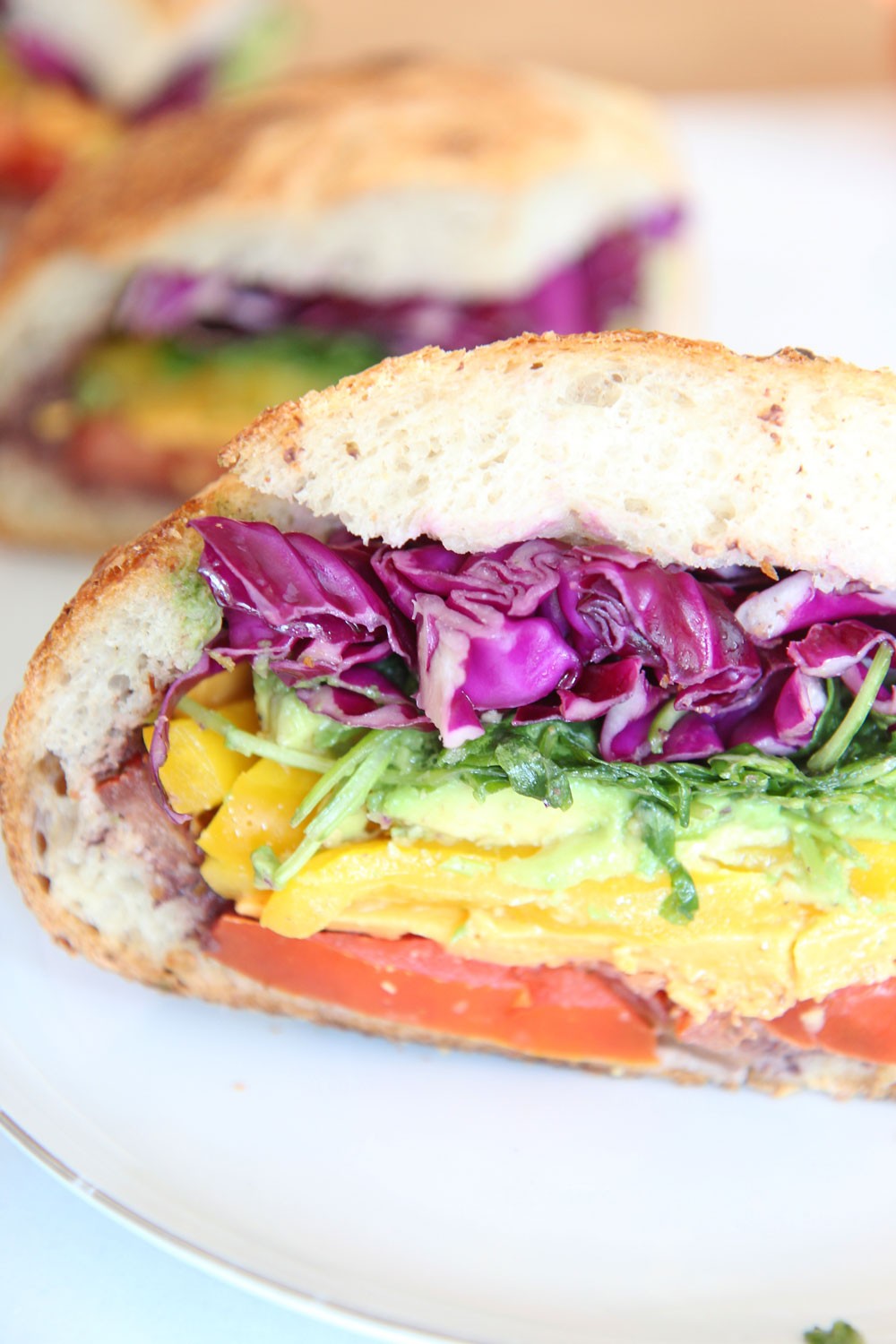 Rainbow Veggie Sandwich with Apple Cider Vinaigrette Recipe. Happy sunshine crunchy rainbow veggie time! This is a great easy healthy sandwich with tang bright flavor for a crowd. Grab yellow peppers, tomatoes, avocado, arugula, cheddar, and cabbage. Then mix apple cider vinaigrette and you have a perfect happy sandwich. #rainbowrecipe #sandwichrecipe