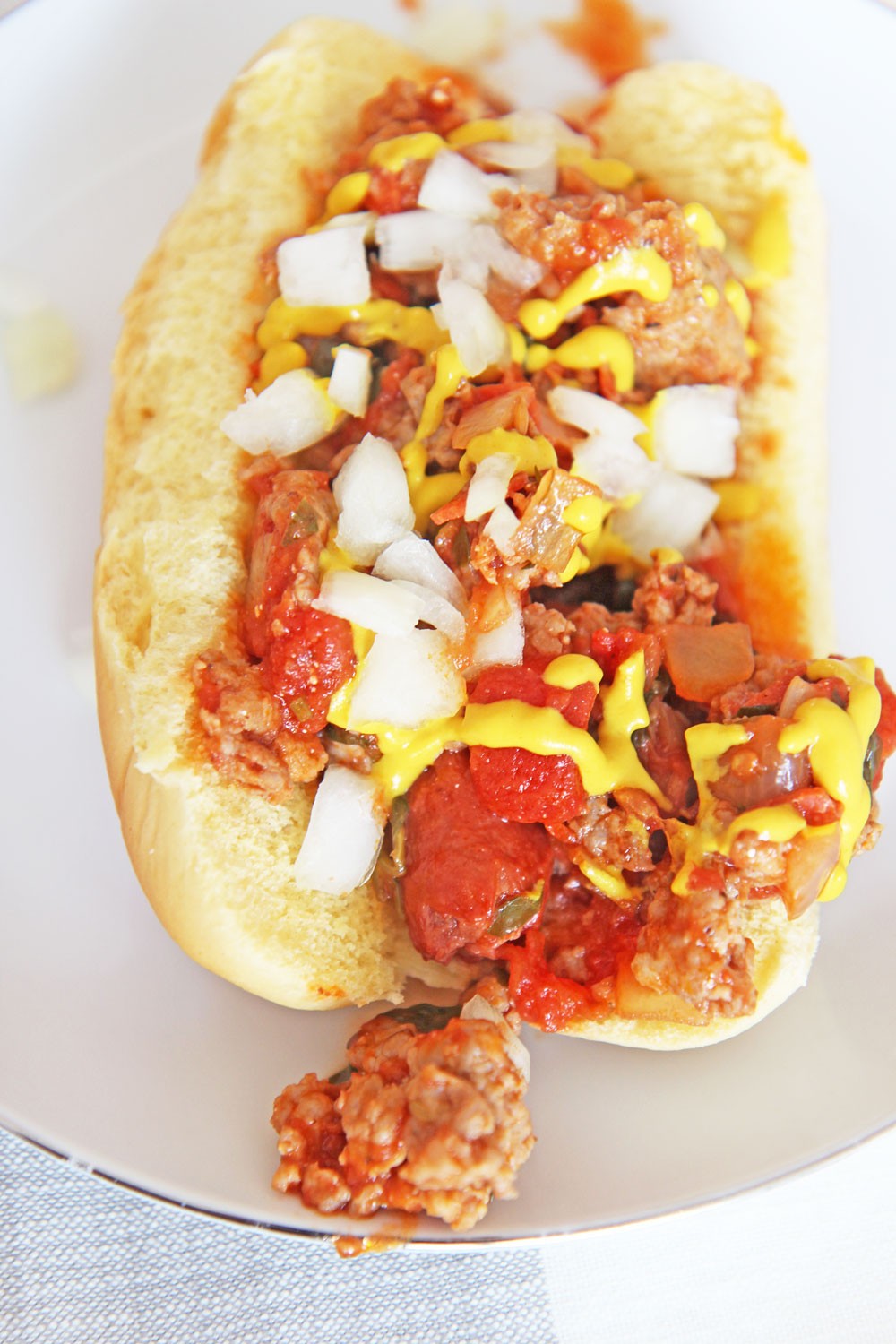 The Best Chili Hot Dog Recipe. Grab your sweet Italian sausage, spicy Italian sausage, crushed tomatoes, onion, garlic, and all your seasonings. This is an easy 30 minute meal with a happy dinner idea. www.ChopHappy.com #chiilidog #hotdog
