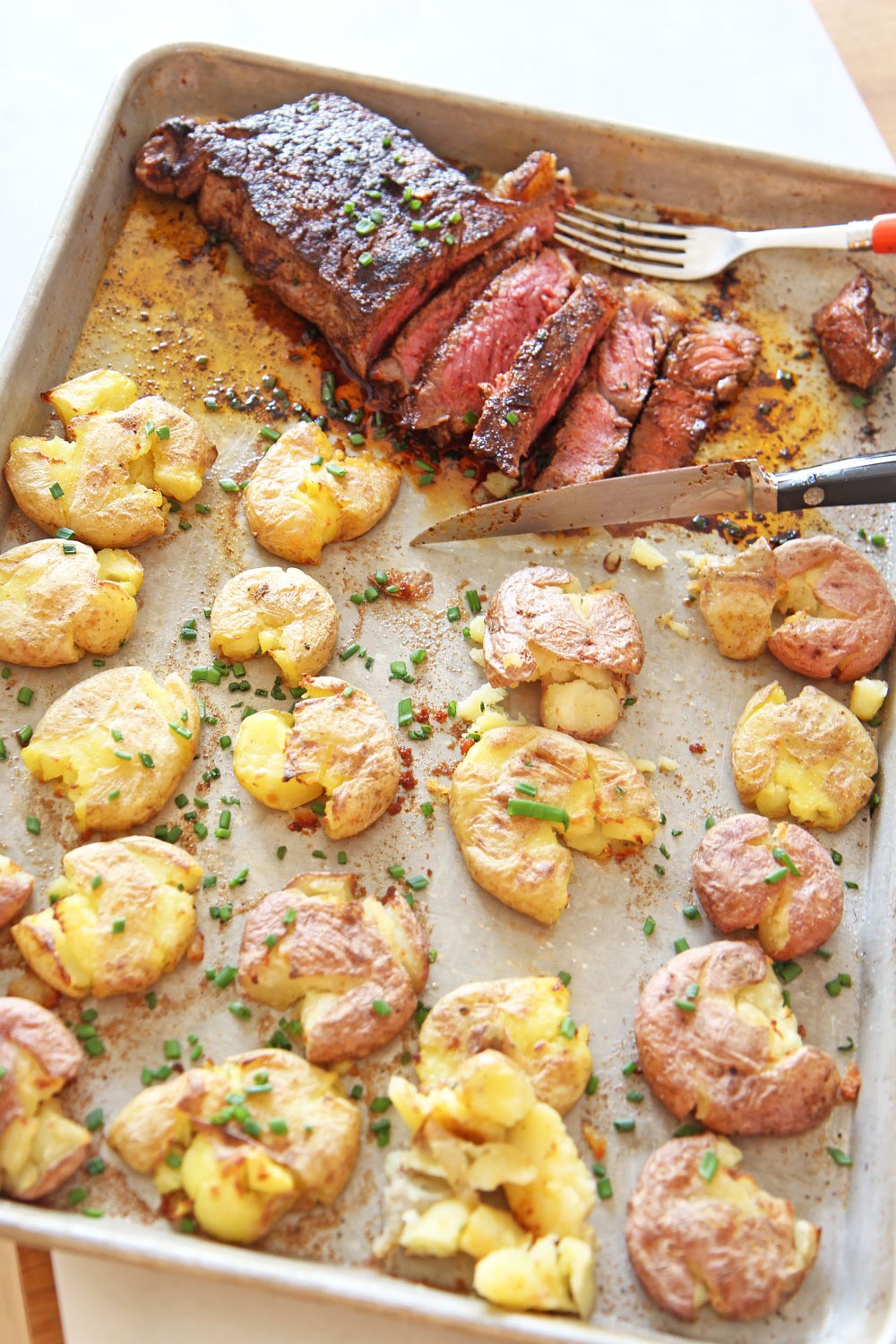 Sheet Pan Steak and Potatoes Recipe. Grab a NY Strip steak, chili seasoning, and lots of Yukon gold potatoes boiled in chicken broth. Easy dinner in less the 30 minutes. Happy weeknight cooking. www.ChopHappy.com #steakdinner #sheetpandinner