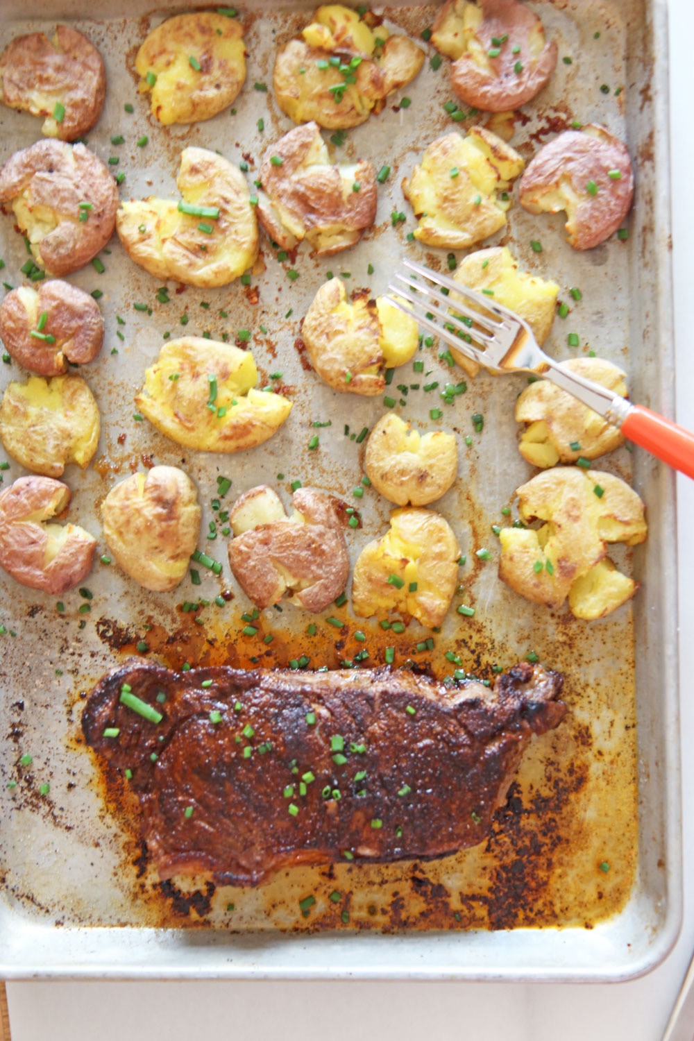 Sheet Pan Steak and Potatoes Recipe. Grab a NY Strip steak, chili seasoning, and lots of Yukon gold potatoes boiled in chicken broth. Easy dinner in less the 30 minutes. Happy weeknight cooking. www.ChopHappy.com #steakdinner #sheetpandinner