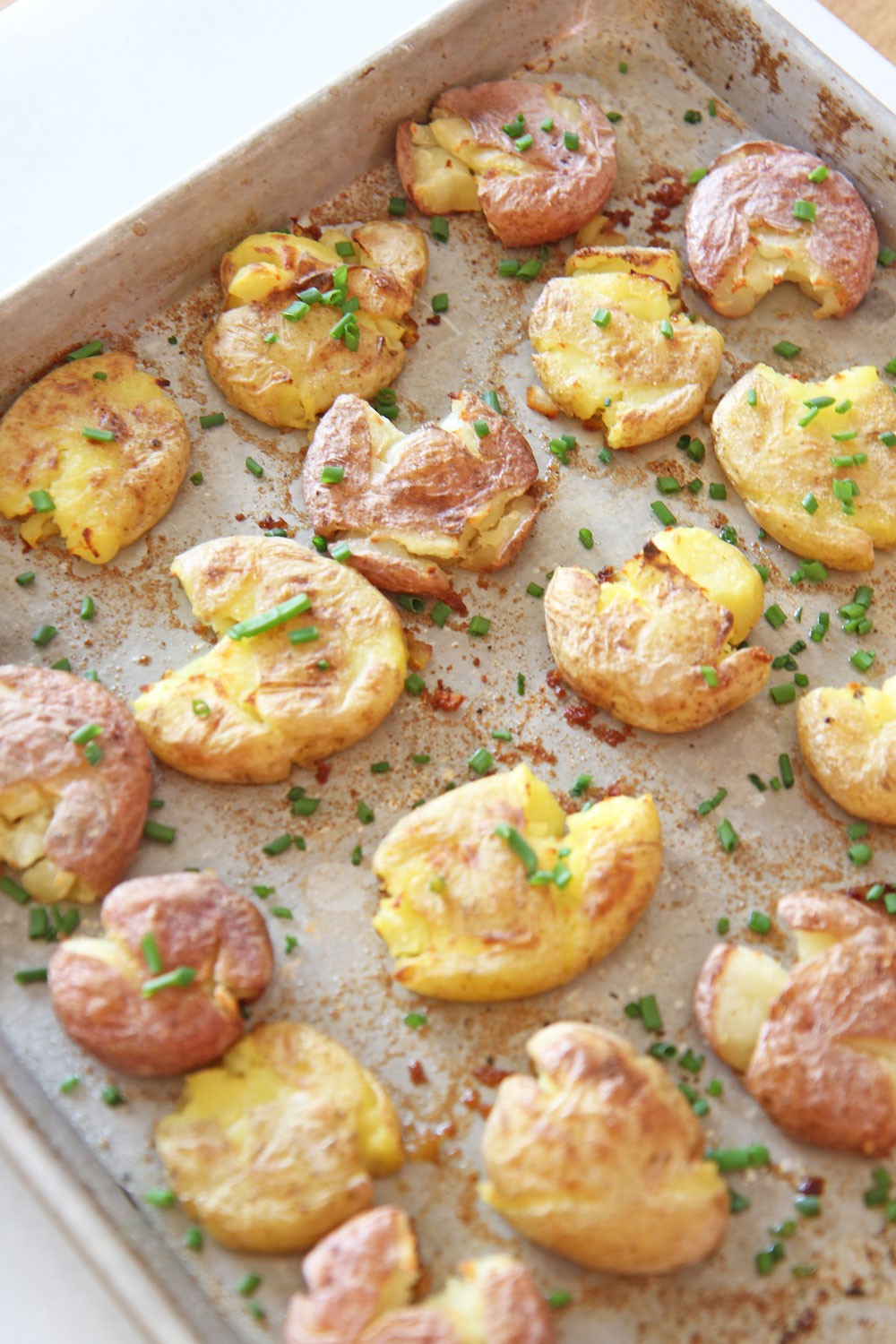 How To Make The Best Crispy Potatoes In The Oven. This is super easy side dish that is a perfect weeknight dinner idea. Grab chicken broth, Yukon gold potatoes, and garlic powder. Happy Sheet Pan Cooking! www.ChopHappy.com #crispypotatoes #howtocookpotatoes
