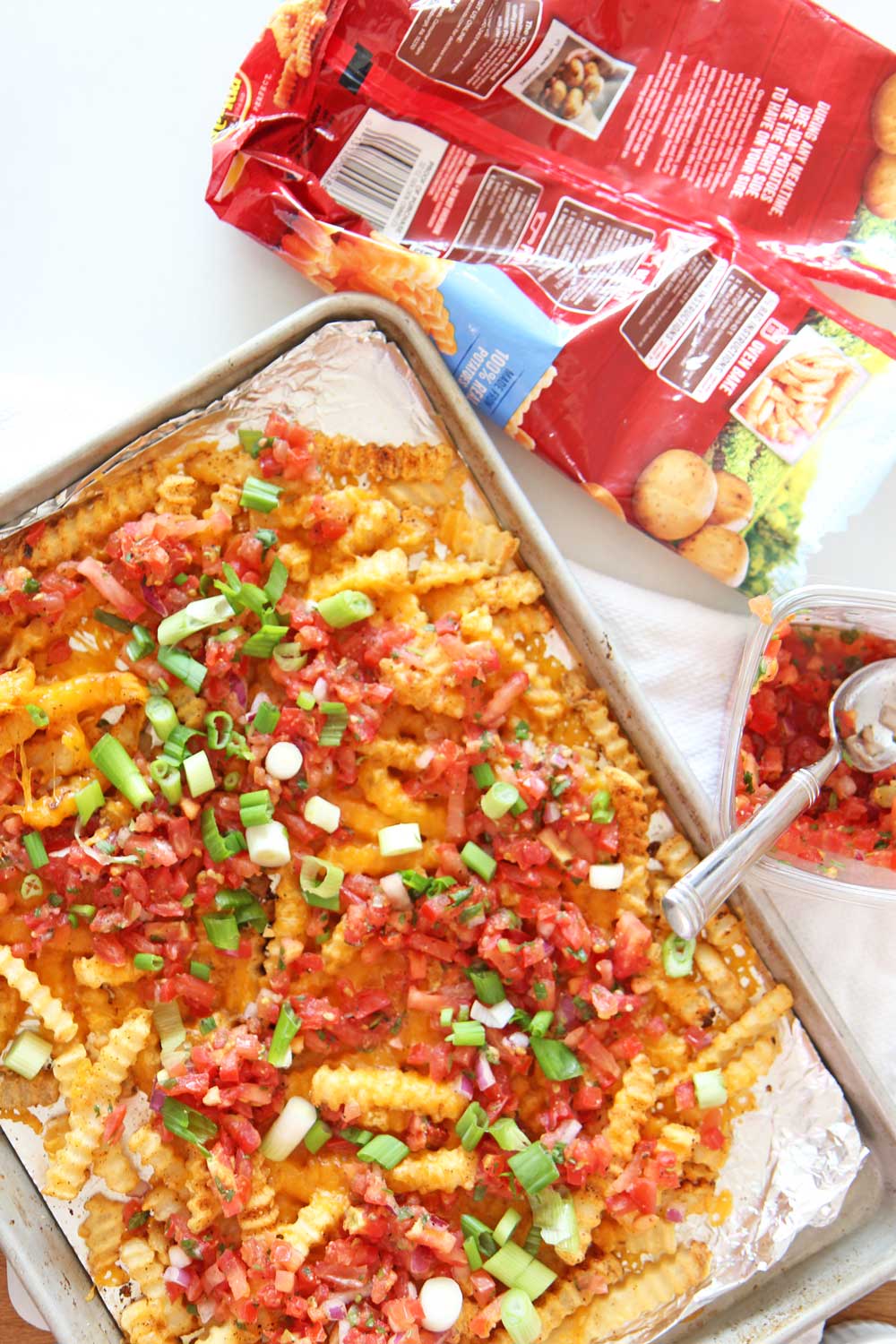 How to Transform Frozen Fries Into Loaded Taco Fries Recipe. Frozen fries, salsa, scallions, cheese, and chili seasoning. Transforming frozen fries is as easy as pantry seasonings cheese, and an oven. Happy sheet pan cooking! www.ChopHappy.com #frozenfries #nachos #pantry 